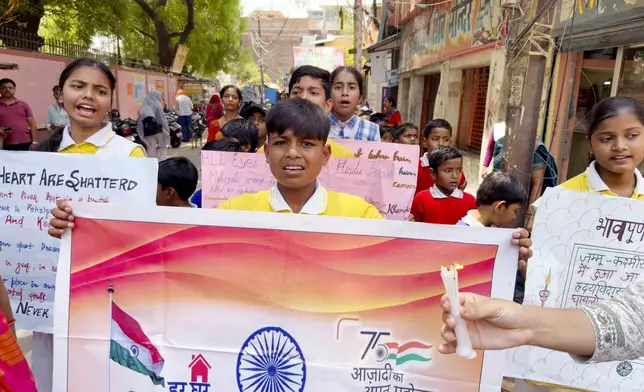 School children walk with candles and banners during a protest and solidarity march against the killing of tourists by militants near Pahalgam in Indian controlled Kashmir, in the northern Indian state of Uttar Pradesh Saturday, April 26, 2025. (AP Photo/Rajesh Kumar Singh)