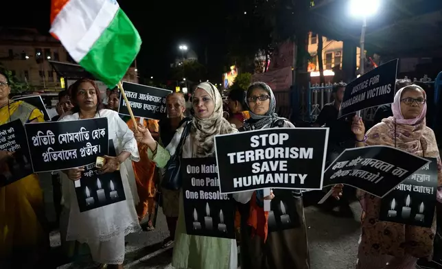 People walk with candles and banners during a protest and solidarity march against the killing of tourists by militants near Pahalgam in Indian controlled Kashmir, in Kolkata, India, Friday, April 25, 2025. (AP Photo/Bikas Das)