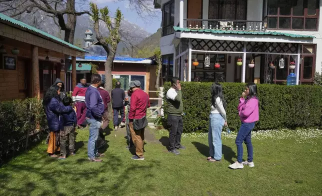 Tourists use their phones to contact loved ones the morning after militants indiscriminately opened fire on tourists near Pahalgam in Indian controlled Kashmir, Wednesday, April 23, 2025. (AP Photo/Dar Yasin)