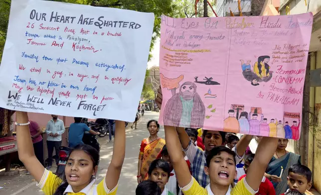 School children walk with candles and banners during a protest and solidarity march against the killing of tourists by militants near Pahalgam in Indian controlled Kashmir, in the northern Indian state of Uttar Pradesh Saturday, April 26, 2025. (AP Photo/Rajesh Kumar Singh)