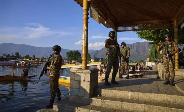 Paramilitary soldiers stand guard at the banks of Dal Lake as Indian tourists take boat rides in Srinagar, Indian controlled Kashmir, Friday, April 25, 2025. (AP Photo/Dar Yasin)
