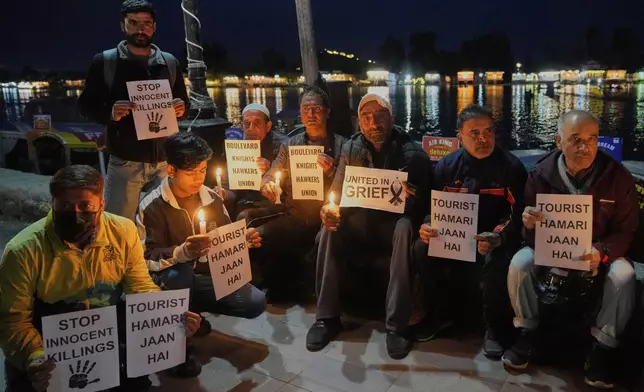 Kashmiri men hold candles and placards as they condemn the tourists killing during a protest in Srinagar, Indian controlled Kashmir, Thursday, April. 24, 2025. (AP Photo/Dar Yasin)