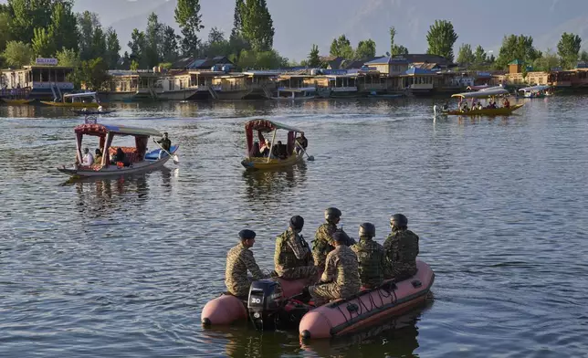 Paramilitary soldiers patrol on an inflatable boat as Indian tourists take boat rides on Dal Lake in Srinagar, Indian controlled Kashmir, Friday, April 25, 2025. (AP Photo/Dar Yasin)