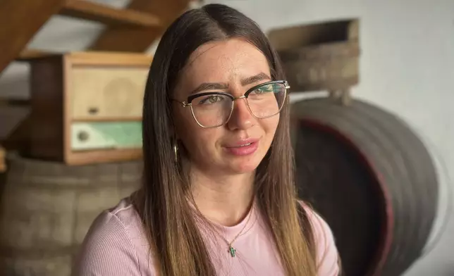 Aliz Alamorean, 23, who recently moved back to Romania after living in Spain since she was five, speaks during an interview with the Associated Press, at the preserves factory where she works in the village of Saschiz, in Romania's central Transylvania region, Friday, April 25, 2025. (AP Photo/Stephen McGrath)