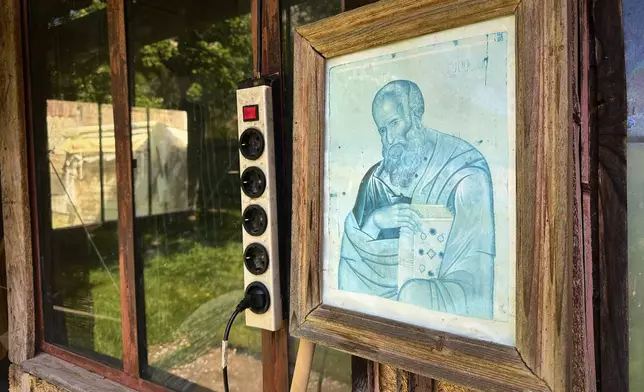 A picture of a religious icon hangs on the wall of a courtyard building at the home of Liliana Cosurean, 54, in the village of Floresti, in Romania's central Transylvania region, Thursday, April 24, 2025. (AP Photo/Stephen McGrath)