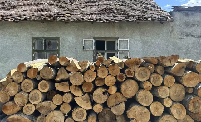 Firewood is stacked outside a house in the village of Saschiz, in Romania's central Transylvania region, Friday, April 25, 2025. (AP Photo/Stephen McGrath)