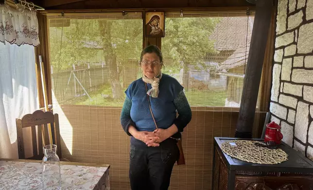 Liliana Cosurean, 54, stands in her home, in the village of Floresti, in Romania's central Transylvania region, Thursday, April 24, 2025. (AP Photo/Stephen McGrath)