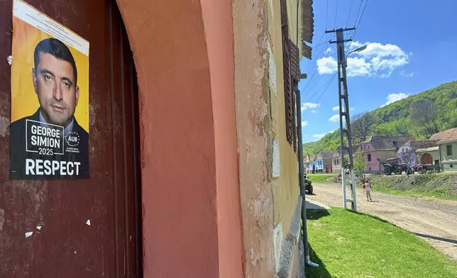 A presidential campaign poster is placed on a door in the village of Floresti, in Romania's central Transylvania region, Thursday, April 24, 2025. (AP Photo/Stephen McGrath)