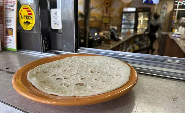 A fresh tortilla covers a large plate at Garcia's Kitchen in Albuquerque, New Mexico, on Thursday, April 10, 2025. (AP Photo/Susan Montoya Bryan)