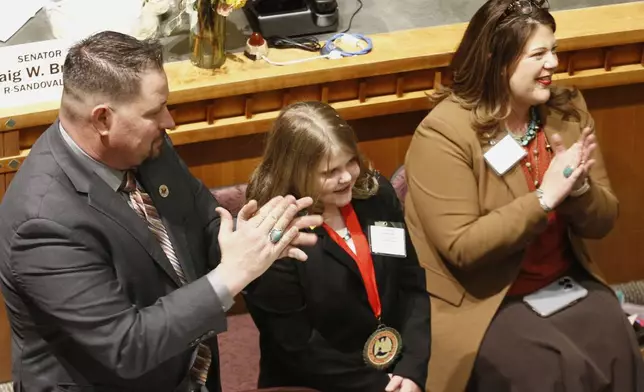 Republican state Sen. Joshua Sanchez of Bosque, N.M., left, applauds a bill to designate tortillas as the official state bread in Santa Fe, on Tuesday, March 18, 2025. (AP Photo/Morgan Lee)