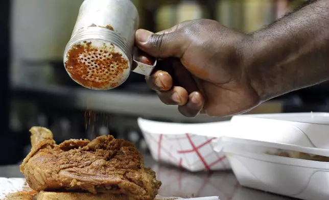 FILE - Keith Graham sprinkles hot seasoning on an order of chicken at Bolton's Spicy Chicken and Fish restaurant in Nashville, Tenn. on Friday, March 22, 2013. (AP Photo/Mark Humphrey,File)