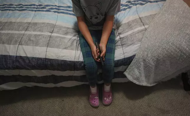 A 9-year-old girl with Temporary Protected Status, or TPS, who was born in Venezuela, but who fluently speaks only English and is in the gifted program at her school, watches TV in her family's apartment, Saturday, April 5, 2025, in Doral, Fla. (AP Photo/Rebecca Blackwell)