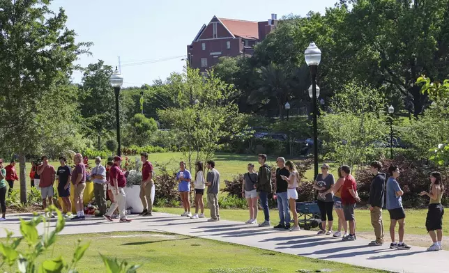Students wait to retrieve their personal items from the Florida State Student Union building, Tallahassee, Fla., Friday, April 18, 2025. (AP Photo/Gary McCullough)