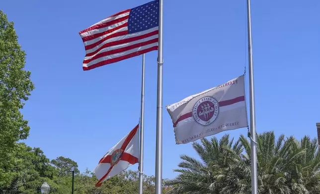Flags flown at half-staff near the Florida State Student Union building, Tallahassee, Fla., Friday, April 18, 2025. (AP Photo/Gary McCullough)
