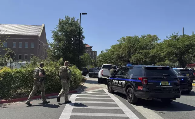 Dozens of patrol vehicles, including a forensics van, are stationed outside of Florida State University’s student union building, the scene of a shooting, Thursday, April 17, 2025, in Tallahassee, Fla. (AP Photo/Kate Payne)