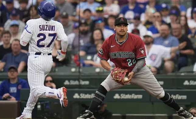 Chicago Cubs designated hitter Seiya Suzuki (27) is tagged out at first by Arizona Diamondbacks first baseman Josh Naylor (22) in a double play during the first inning of a baseball game Friday, April 18, 2025, in Chicago. (AP Photo/Erin Hooley)