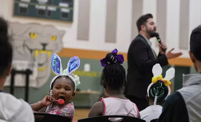 Children wear easter bunny ears as River Church Cincinnati pastor Cory Bowman preaches during Easter worship service in the Hays Porter Elementary School gym Sunday, April 20, 2025, in Cincinnati. Bowman, Vice President JD Vance's half-brother, is running for Cincinnati Mayor. (AP Photo/Carolyn Kaster)