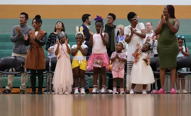 Parishioners stand to worship with Pastor Cory Bowman at River Church Cincinnati's Easter worship service in the Hays Porter Elementary School gym, Sunday, April 20, 2025, in Cincinnati. Cory . (AP Photo/Carolyn Kaster)
