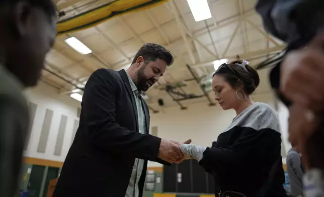 River Church Cincinnati pastor Cory Bowman, who is Vice President JD Vance's half brother and Cincinnati mayoral candidate, left, prays with Rebecca Perez during Easter worship service in the Hays Porter Elementary School gym Sunday, April 20, 2025, in Cincinnati. (AP Photo/Carolyn Kaster)