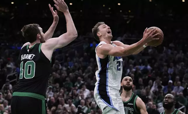 Orlando Magic forward Franz Wagner, right, drives to the basket against Boston Celtics center Luke Kornet (40) during the first half in Game 5 of a first-round NBA playoff basketball series, Tuesday, April 29, 2025, in Boston. (AP Photo/Charles Krupa)