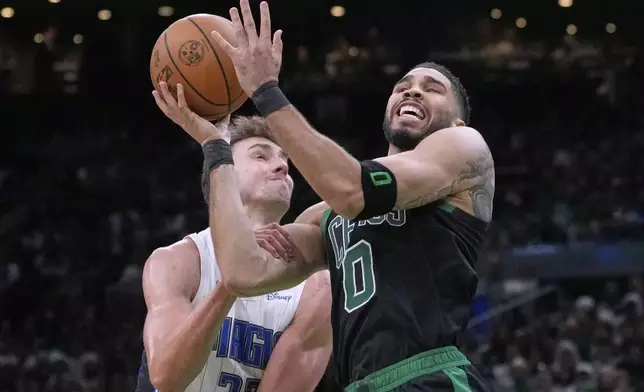 Boston Celtics forward Jayson Tatum (0) is fouled by Orlando Magic forward Franz Wagner (22) on a drive to the basket during the second half in game 5 of a first-round NBA playoff basketball series, Tuesday, April 29, 2025, in Boston. (AP Photo/Charles Krupa)
