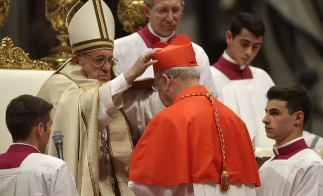 FILE - New Cardinal Kevin Joseph Farrell, prefect of the Vatican dicastery for laity, family and life, receives the red three-cornered biretta hat from Pope Francis inside St. Peter's Basilica at the Vatican on Nov. 19, 2016. (AP Photo/Gregorio Borgia, File)