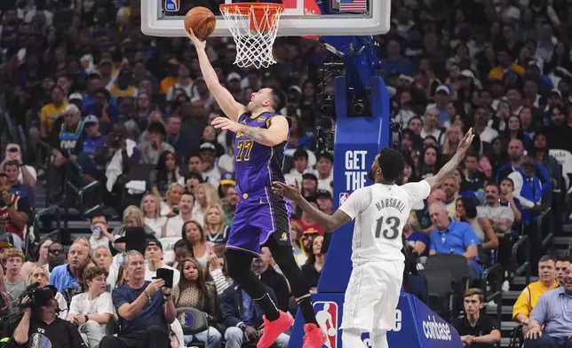 Los Angeles Lakers' Luka Doncic (77) shoots as Dallas Mavericks' Naji Marshall (13) defends in the first half of an NBA basketball game in Dallas, Wednesday, April 9, 2025. (AP Photo/LM Otero)