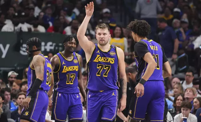 Los Angeles Lakers' Luka Doncic (77) gestures as he walks on the court during a time out in the first half of an NBA basketball game against the Dallas Mavericks in Dallas, Wednesday, April 9, 2025. (AP Photo/LM Otero)