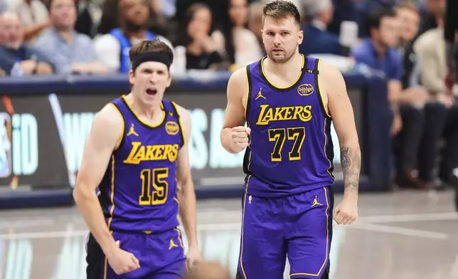 Los Angeles Lakers' Austin Reaves (15) and Luka Doncic (77) celebrate in the second half of an NBA basketball game against the Dallas Mavericks in Dallas, Wednesday, April 9, 2025. (AP Photo/LM Otero)