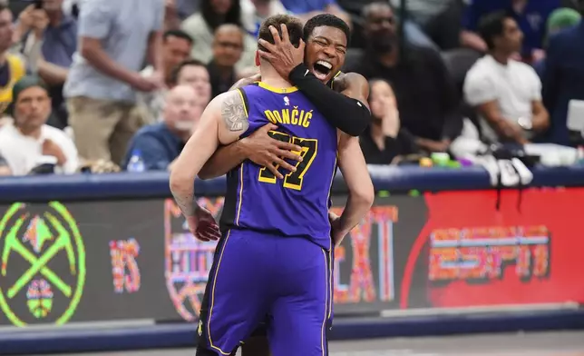 Los Angeles Lakers' Luka Doncic (77) and Rui Hachimura, center right, celebrate late in the second half of an NBA basketball game against the Dallas Mavericks in Dallas, Wednesday, April 9, 2025. (AP Photo/LM Otero)