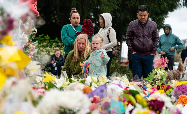 Mourners leaves flowers at a memorial site for the victims of an incident where a car drove through a crowd killing multiple people in Vancouver, British Columbia, Monday, April 28, 2025. (Rich Lam/The Canadian Press via AP)