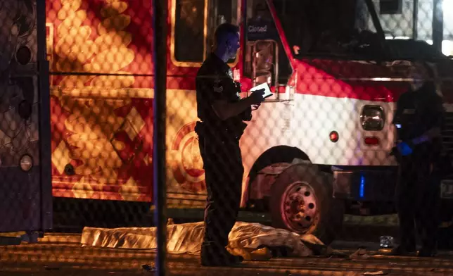 A victim lies near a food truck after a car drove into a crowd at the Lapu Lapu Festival in Vancouver on Saturday April 26, 2025. (Rich Lam/The Canadian Press via AP)