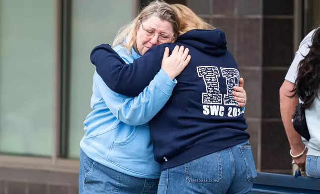 Women console each other after leaving flowers near the site where a vehicle drove into crowd at a Lapu Lapu Day festival in Vancouver, British Columbia, Sunday, April 27, 2025. (Rich Lam/The Canadian Press via AP)