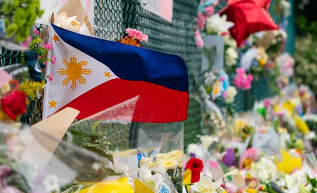 A Philippines flag waves in the wind at a memorial site for the victims of an incident where a car drove through a crowd killing multiple people in Vancouver, British Columbia, Monday, April 28, 2025. (Rich Lam/The Canadian Press via AP)
