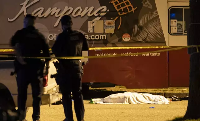 A victim covered with a cloth lies near a food truck after a car drove into a crowd at the Lapu Lapu Festival in Vancouver, British Columbia, Saturday April 26, 2025. (Rich Lam/The Canadian Press via AP)