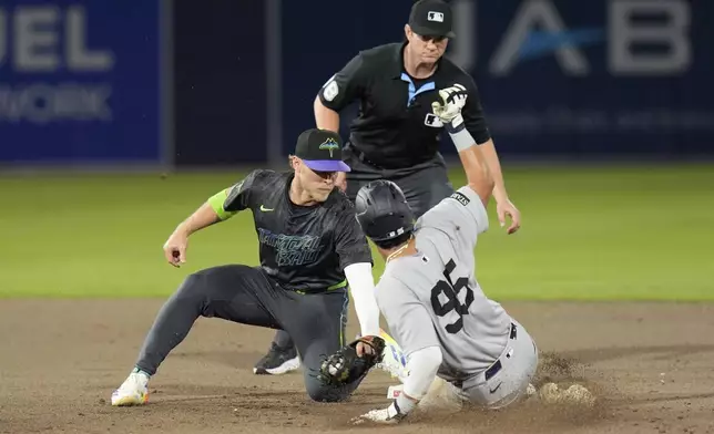 Tampa Bay Rays shortstop Taylor Walls tags out New York Yankees' Oswaldo Cabrera (95) attempting to steal second base during the eighth inning of a baseball game Friday, April 18, 2025, in Tampa, Fla. (AP Photo/Chris O'Meara)