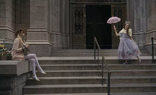 Revelers wearing decorated hats and costumes pose and take a break during the annual Easter Parade and Bonnet Festival in front of St. Patrick's Cathedral on Sunday, April 20, 2025, in New York. (AP Photo/Andres Kudacki)