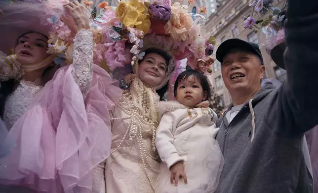 A man takes a selfie with revelers wearing decorated hats and costumes as they participate in the annual Easter Parade and Bonnet Festival in front of St. Patrick's Cathedral on Sunday, April 20, 2025, in New York. (AP Photo/Andres Kudacki)