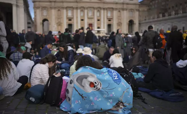 Faithful wait for the start of the funeral of Pope Francis in St. Peter's Square at the Vatican, Saturday, April 26, 2025. (AP Photo/Emilio Morenatti)