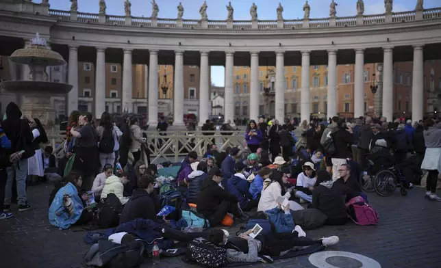 Faithful sit in St. Peter's Square waiting for the funeral of Pope Francis to begin, at the Vatican, Saturday, April 26, 2025. (AP Photo/Emilio Morenatti)