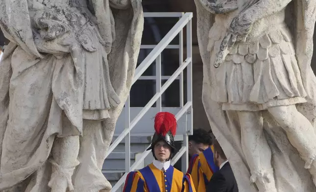 A Pontifical Swiss guard looks up at a statue ahead of the funeral of Pope Francis in St. Peter's Square at the Vatican, Saturday, April 26, 2025. (AP Photo/Markus Schreiber)