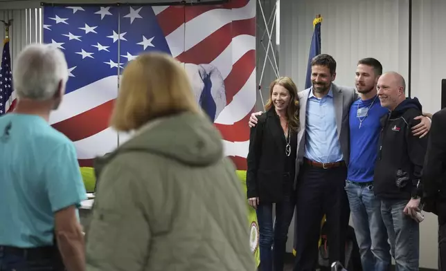 Ryan Kelley, third from right, poses for photos after his talk at the Jackson County Republican headquarters, Thursday, April 10, 2025, in Jackson, Mich. (AP Photo/Paul Sancya)