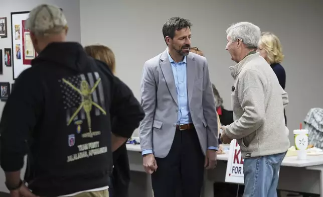 Ryan Kelley, left, talks with William "Hank" Choate before speaking at the Jackson County Republican headquarters Thursday, April 10, 2025, in Jackson, Mich. (AP Photo/Paul Sancya)