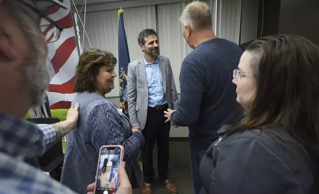 Ryan Kelley, center, speaks with attendees after his talk at the Jackson County Republican headquarters, Thursday, April 10, 2025, in Jackson, Mich. (AP Photo/Paul Sancya)
