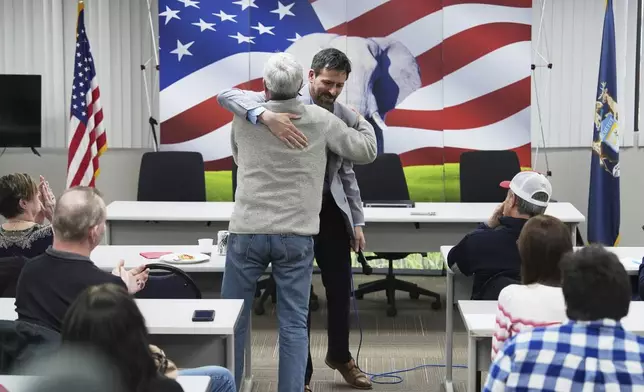 Ryan Kelley, right, hugs William "Hank" Choate during his talk at the Jackson County Republican headquarters Thursday, April 10, 2025, in Jackson, Mich. (AP Photo/Paul Sancya)