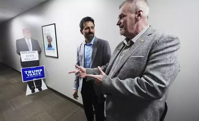 Ryan Kelley, left, talks with Russ Jennings, chairman of the Jackson County Republican Committee, before speaking, Thursday, April 10, 2025, in Jackson, Mich. (AP Photo/Paul Sancya)