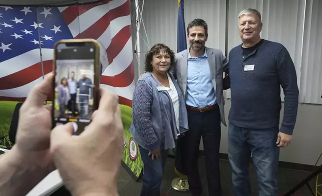 Ryan Kelley, center, poses for a photo after his talk at the Jackson County Republican headquarters, Thursday, April 10, 2025, in Jackson, Mich. (AP Photo/Paul Sancya)