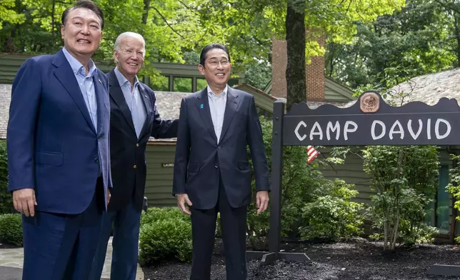 FILE - President Joe Biden greets South Korea's President Yoon Suk Yeol, left, and Japan's Prime Minister Fumio Kishida, right, on Aug. 18, 2023, at Camp David, the presidential retreat, near Thurmont, Md. (AP Photo/Andrew Harnik, File)