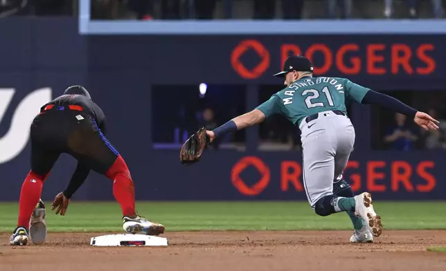 Toronto Blue Jays' Bo Bichette, left, is safe at second with a stolen base ahead of a tag by Seattle Mariners second baseman Miles Mastrobuoni (21) in the first inning of a baseball game in Toronto on Friday, April 18, 2025. (Jon Blacker/The Canadian Press via AP)