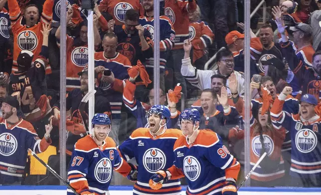 Edmonton Oilers' Connor McDavid (97), Evan Bouchard (2) and Corey Perry (90) celebrate a goal against the Los Angeles Kings during the third period of an NHL hockey playoff game in Edmonton, Alberta, Friday, April 25, 2025. (Jason Franson/The Canadian Press via AP)